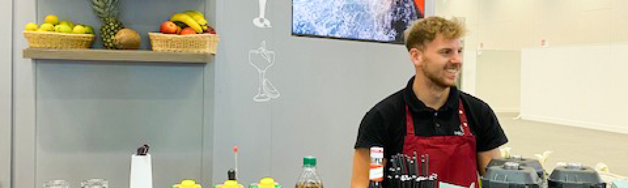 Barkeeper hinter einer mobilen Smoothiebar auf einer Messe
